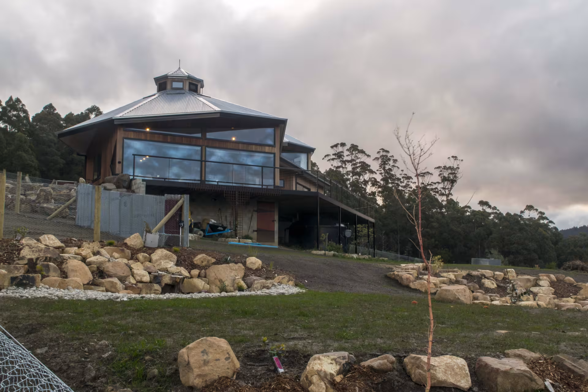 A recently built house on a hill with extensive glass and landscaped gardens in Oyster Cove, Tasmania