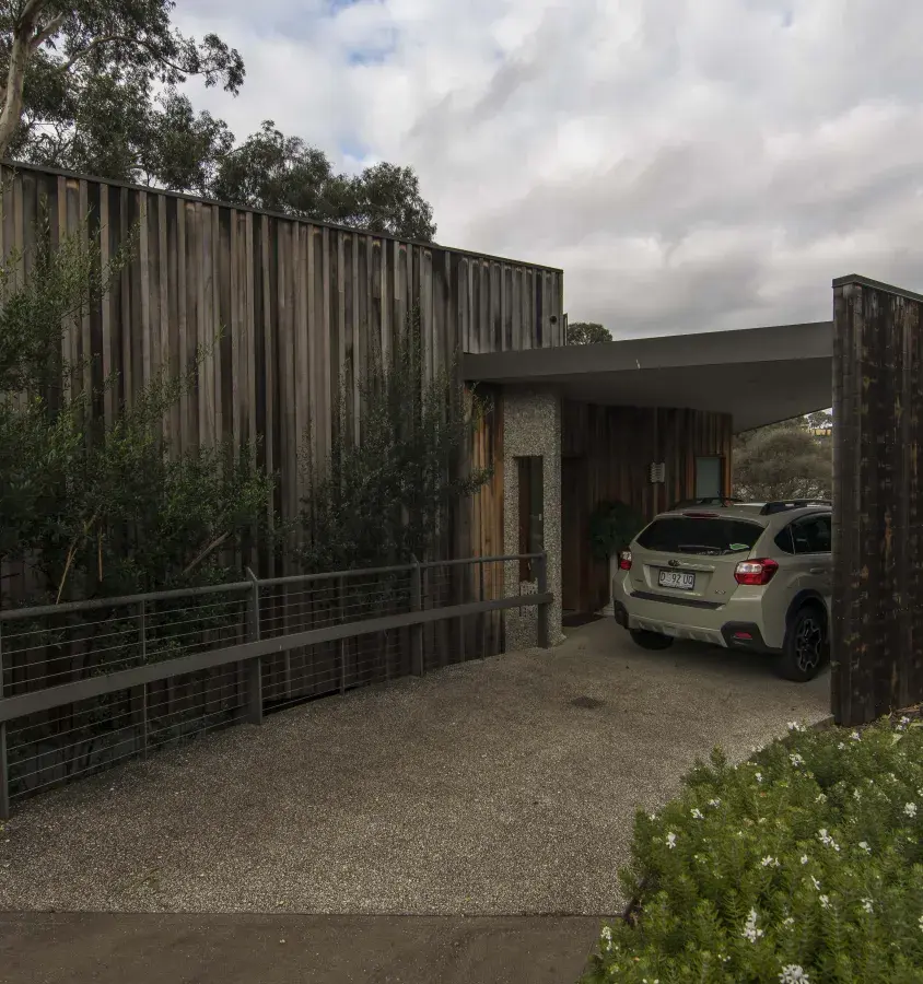 Modern looking carport entry with exposed aggregate driveway and house in vertical timber cladding in Blackman's Bay, Tasmania